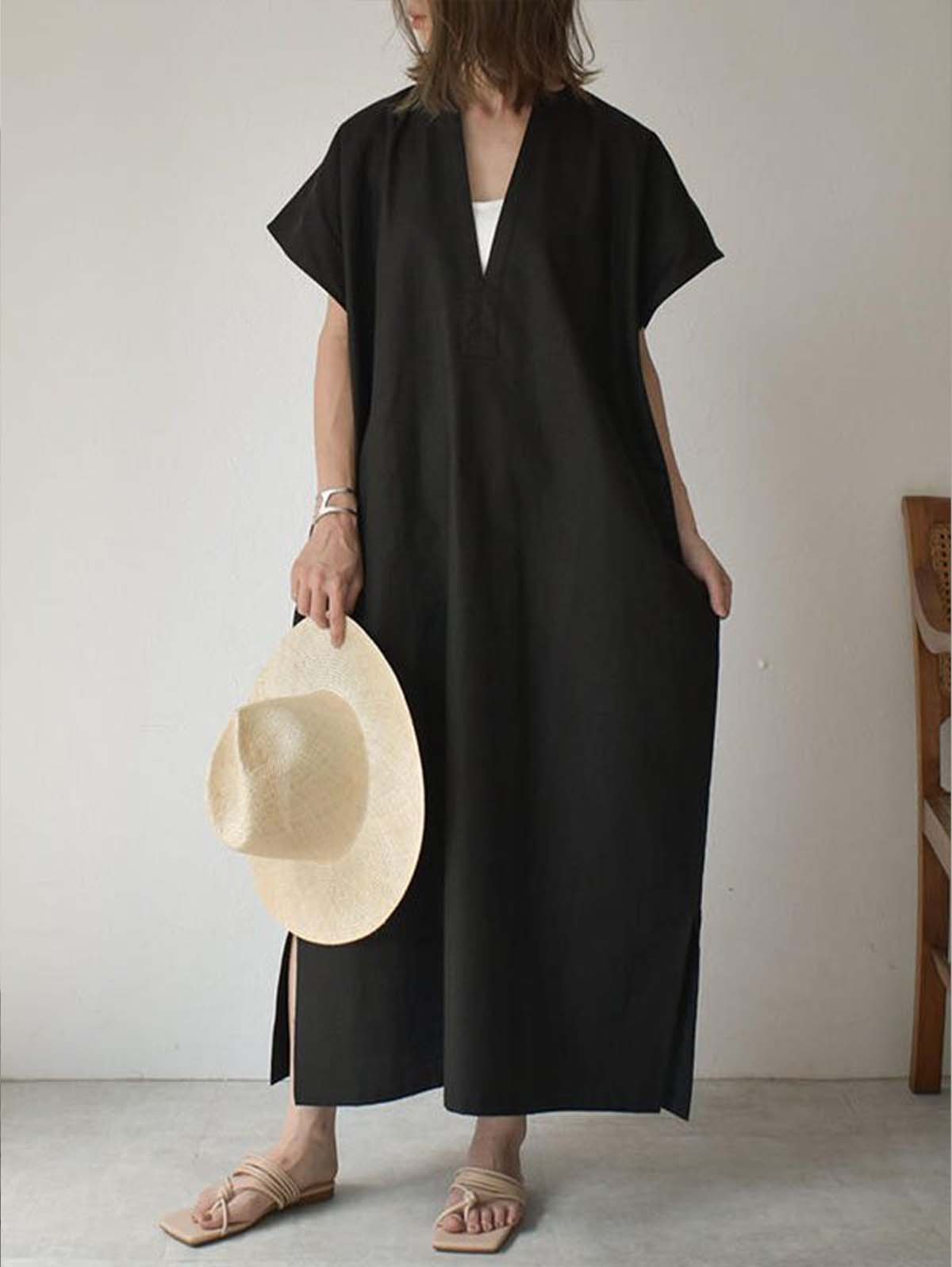 Einfaches schwarz-beiges Maxikleid mit Fledermausärmeln und seitlichen Schlitzen